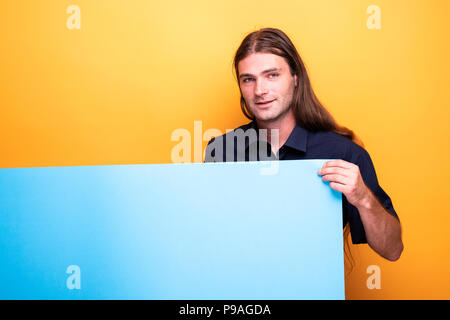 Handsome male adult holding empty advertise banner Stock Photo