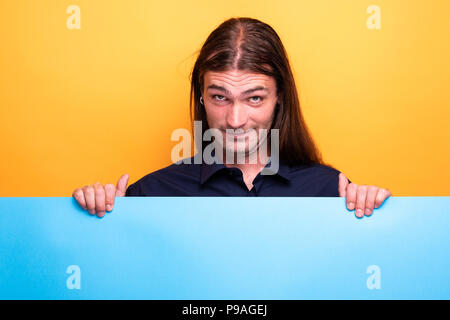 Adult man making grimace while holding cardboard Stock Photo