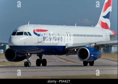 A British Airways Airbus A320-232 taxis along the runway at Manchester Airport whilst preparing to take off. Stock Photo
