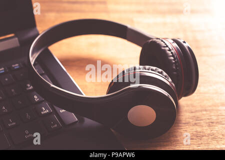Small Black Wireless Gaming Headset Leaning On The Keyboard Of A Notebook Stock Photo