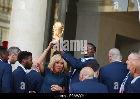 Paris, France. 16th July 2018. Brigitte Macron and Paul Pogba hold the World Cup trophy as the French football team is welcomed at the presidential Elysee palace in the wake of its World Cup victory. Brigitte Macron et Paul Pogba brandissent le trophee de la Coupe du Monde tandis que les joueurs de l'equipe de France de football sont accueillis a l'Elysee apres leur victoire en Coupe du Monde. *** FRANCE OUT / NO SALES TO FRENCH MEDIA *** Credit: Idealink Photography/Alamy Live News Stock Photo