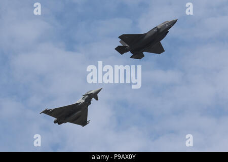 Farnborough, UK. 16th July 2018. A Royal Air Force Lockheed Martin F-35B and Eurofighter Typhoon perform a flypast on the opening day of the 2018 Farnborough International Airshow, one of the biggest aviation trade and industry events in the world, held in the UK. Credit: James Hancock/Alamy Live News Stock Photo