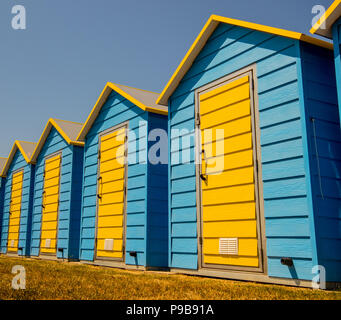 Modern beach huts on the greensward near the promenade at Felpham seafront near Bognor Regis, West Sussex, UK Stock Photo