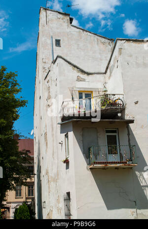 An old cracked buliding with windows and balconies in a european city. Stock Photo