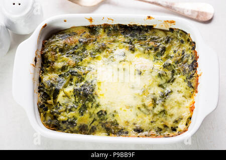Potato and spinach gratin in creamy garlic sauce Stock Photo