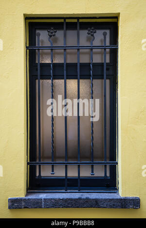 window with black gate and yellow wall security burglar Stock Photo