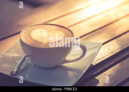 Tasty looking latte art coffee background concept, morning wooden table top image Stock Photo