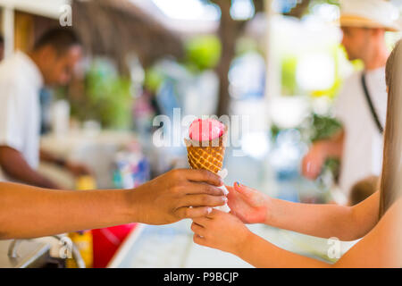 Handing over fresh ice cream to buyer. Summer beach mood with refreshing ice cream Stock Photo