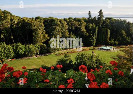 View of flowering gardens and lawn with fountain from Historic Grand Hotel on resort island of Mackinac Island, Michigan, USA. Stock Photo