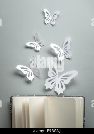 Paper butterflies on open book Stock Photo