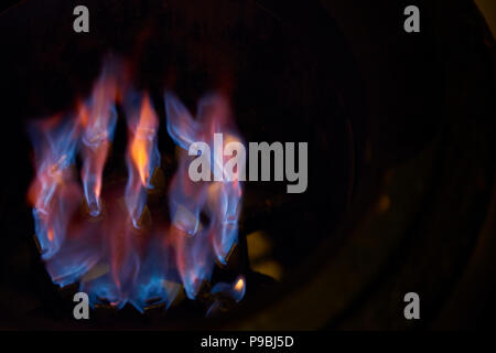 Gas burner lit with fire on an industrial stove top. Stock Photo