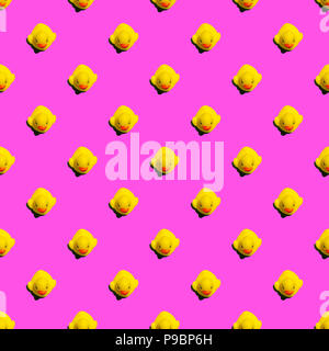 Small yellow rubber ducks on pink background seamless pattern; summer background Stock Photo