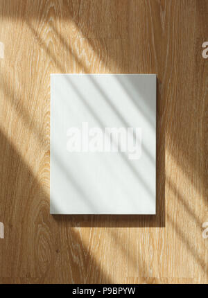 Blank canvas with portrait orientation on wooden wall in sun rays Stock Photo