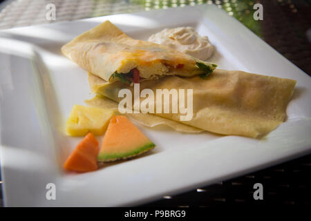 Sliced Stuffed Breakfast Crepe with eggs, Spinach and Cheese Stock Photo