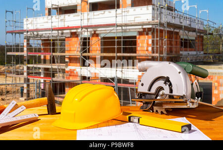 Helmet, tools and circular saw with a shell in the background Stock Photo