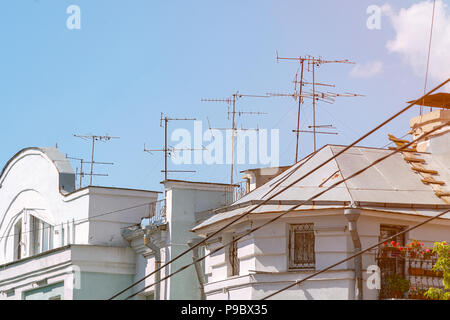 TV Antenna on the roof of the house against the blue sky Stock Photo