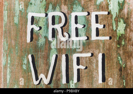 Wooden textured board with painted handwritten text 'Free Wifi' in cafe Stock Photo