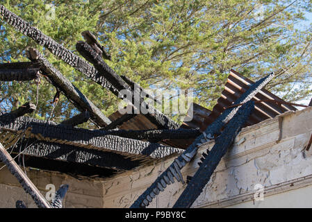 The charred timber beams of the burnt out roof of the old cottage at the Maltings in Mittagong NSW, Australia Stock Photo