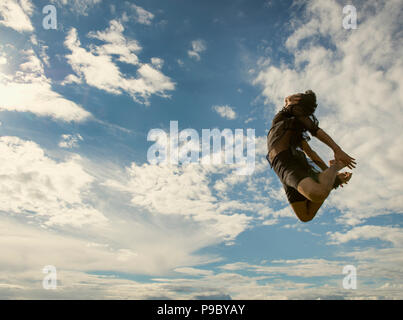 A young man gracefully leaping into the air. Stock Photo