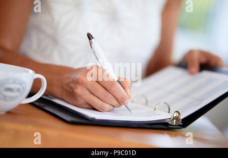 Woman writing in a diary Stock Photo