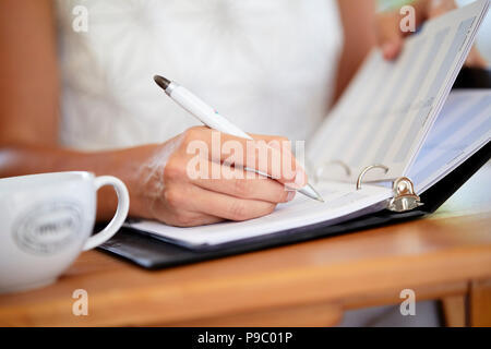 Woman writing in a diary Stock Photo