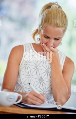 Woman writing in a diary Stock Photo