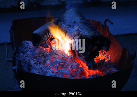 Glowing embers of wooden in a round fire pit Stock Photo