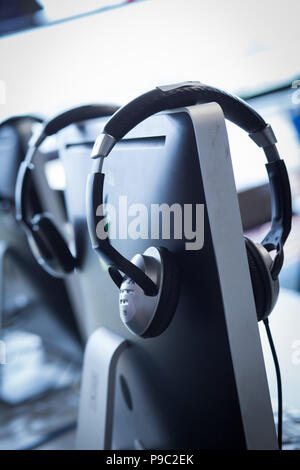 Row of headphones on an iMac computer Stock Photo