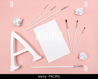 Arts and creativity. Letter A, paintbrushes and blank paper, on pastel pink background. Stock Photo