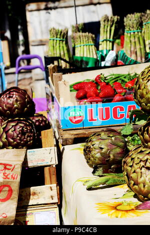 Artichokes, asparagus and strawberries on sale at a local fruit and vegetable market stall in Rome, Italy (Farmer's Market Via Urbano II) Stock Photo