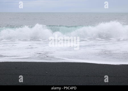 Breaking wave on black volcanic sand beach in Iceland Stock Photo