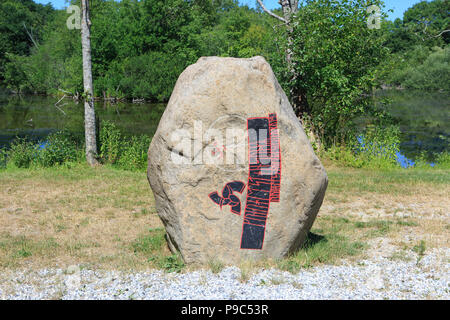 A sacred Neolithic-Iron Age runestone with a gammadion (swastika) and tiskelion (triple spiral) at The Land of Legends in Lejre, Denmark Stock Photo