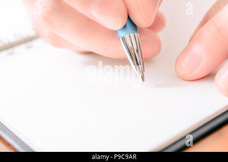 Close-Up Of A Male Hand Writing In A Blank Organizer With A Biro Stock Photo