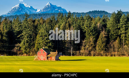 Abandoned old farm with snowy mountains in the background. Stock Photo