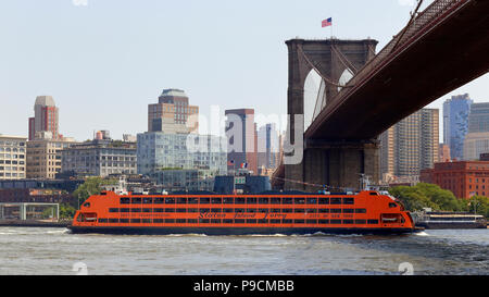 A Staten Island Ferry boat passes under the Brooklyn Bridge