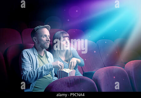 Teenager couple cuddling and watching the climax part of the movie Stock Photo