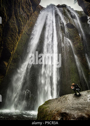 21 April 2018: South Iceland - Gljufrabui Waterfall, and a man taking a photo with his cell phone. Stock Photo