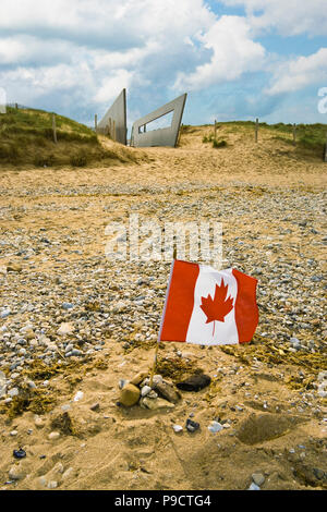 Small Canadian flag left in remembrance on Juno beach, Courseulles-sur-mer, Normandy, France, Europe Stock Photo