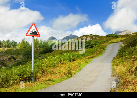 Road sign and small hillside country road in countryside with warning of 25 percent gradient ahead, Cumbria, England UK Stock Photo