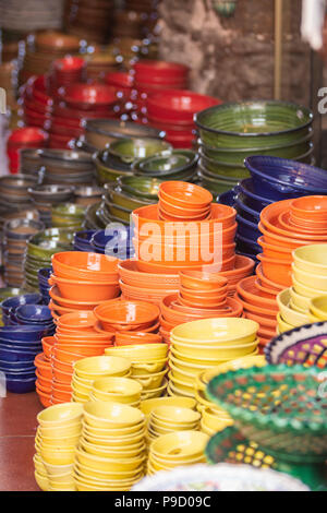 Stacks of ceramic bowls of various sizes and colors standing on stall in marketplace Stock Photo