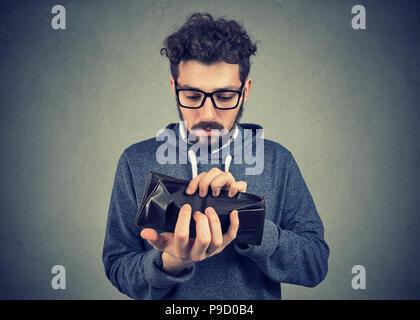 Sad man with no money holding an empty wallet Stock Photo