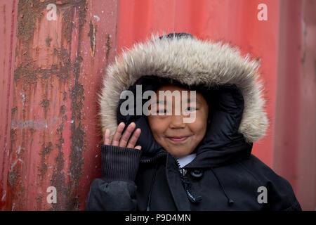 Canada, Nunavut, western shore of Hudson Bay, Kivalliq Region, Arviat. Young boy waving. Stock Photo