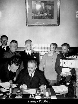 Soviet Foreign Minister Molotov signs the German-Soviet nonaggression pact (Behind: Joachim von Ribbentrop and Joseph Stalin). Museum: State History Museum, Moscow. Stock Photo
