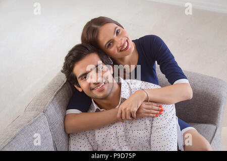 Young woman leaning over a young man from behind Stock Photo