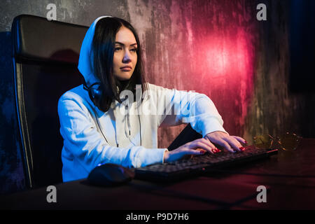 young hooded female hacker developing malware Stock Photo