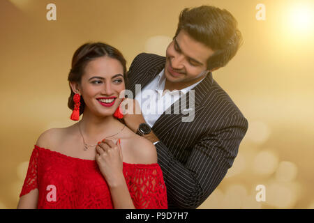 Man putting necklace on his girlfriend Stock Photo