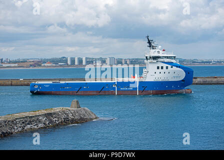 The Nao Galaxy oil platform supply ship heads down the river Dee in Aberdeen Scotland before making it's way across the North Sea. Stock Photo