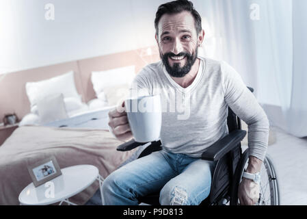 Joyful differently abled male giving cup Stock Photo
