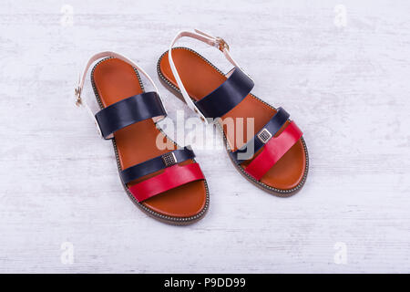 Pair of fashionable women's sandals on white wooden background. Stock Photo