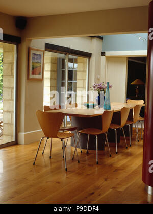 Arne Jacobsen style chairs and wooden table in modern dining room